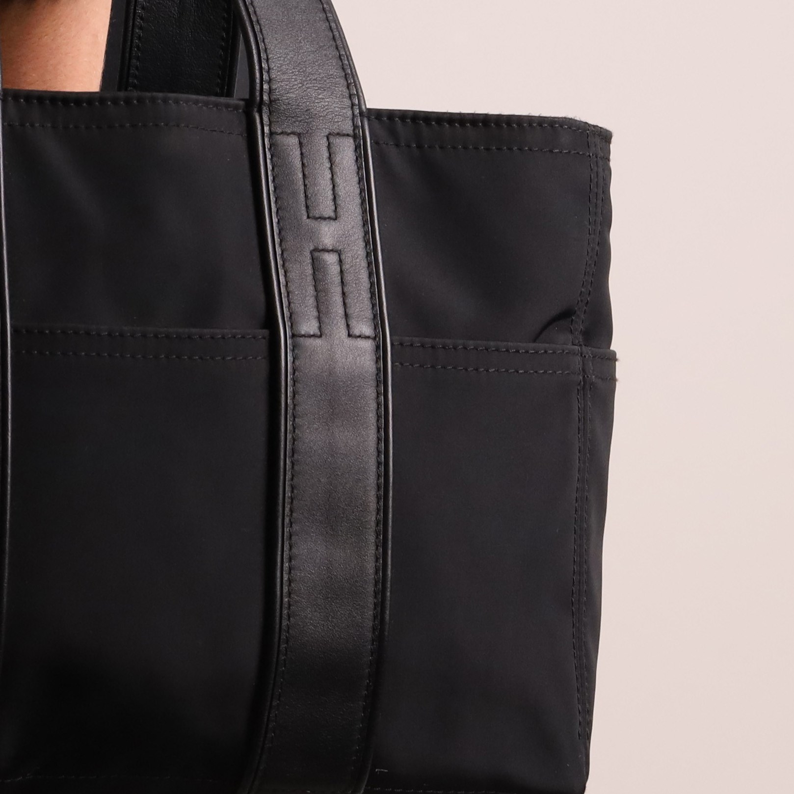 Hermès - Acapulco PM tote bag in black Toile Chevron canvas with black leather trim, the rectangular body with twin flat handles incorporating stitched H details, top zip fastening and eight exterior slip pockets, opening to a black nylon-lined interior with zip pocket, palladium-tone hardware, stamped Hermès Paris Made in France, with original Hermes dust bag
