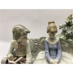 Lladro figure, Poetry of Love, modelled as a boy seated reading from a book next to a girl on garden bench with a dog at her feet, sculpted by Regino Torrijos, with original box, no 5442, year issued 1987, year retired 1998, H22cm