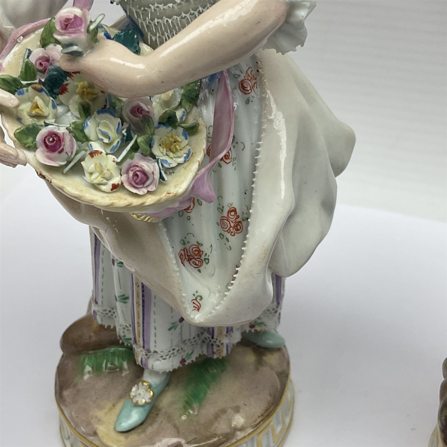 Pair of late 19th/early 20th Century Meissen figures, modelled as flower sellers, after the original by Michel Victor Acier, she holding basket of flowers, he holding flowers in his hat, each with underglaze cross swords mark beneath, tallest H16.5cm