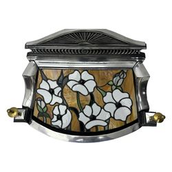Stained glass and cast iron electric fireplace, arched top with decorative finials, stained glass front panel with floral motifs, flanked by cast iron scrolls, raised on scroll supports