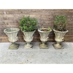 Set of four Victorian design cast stone Grecian urns, tapering form cast with figures and handles, square plinth bases