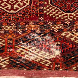 Vintage Bokhara hand-knotted rug, madder field woven in rows of octagonal Tekke guls arranged in vertical columns, each enclosing angular cruciform devices and tribal motifs, divided by narrow indigo lines, within multiple geometric borders incorporating stepped lozenges and latch hook devices, with cotton fringe ends 