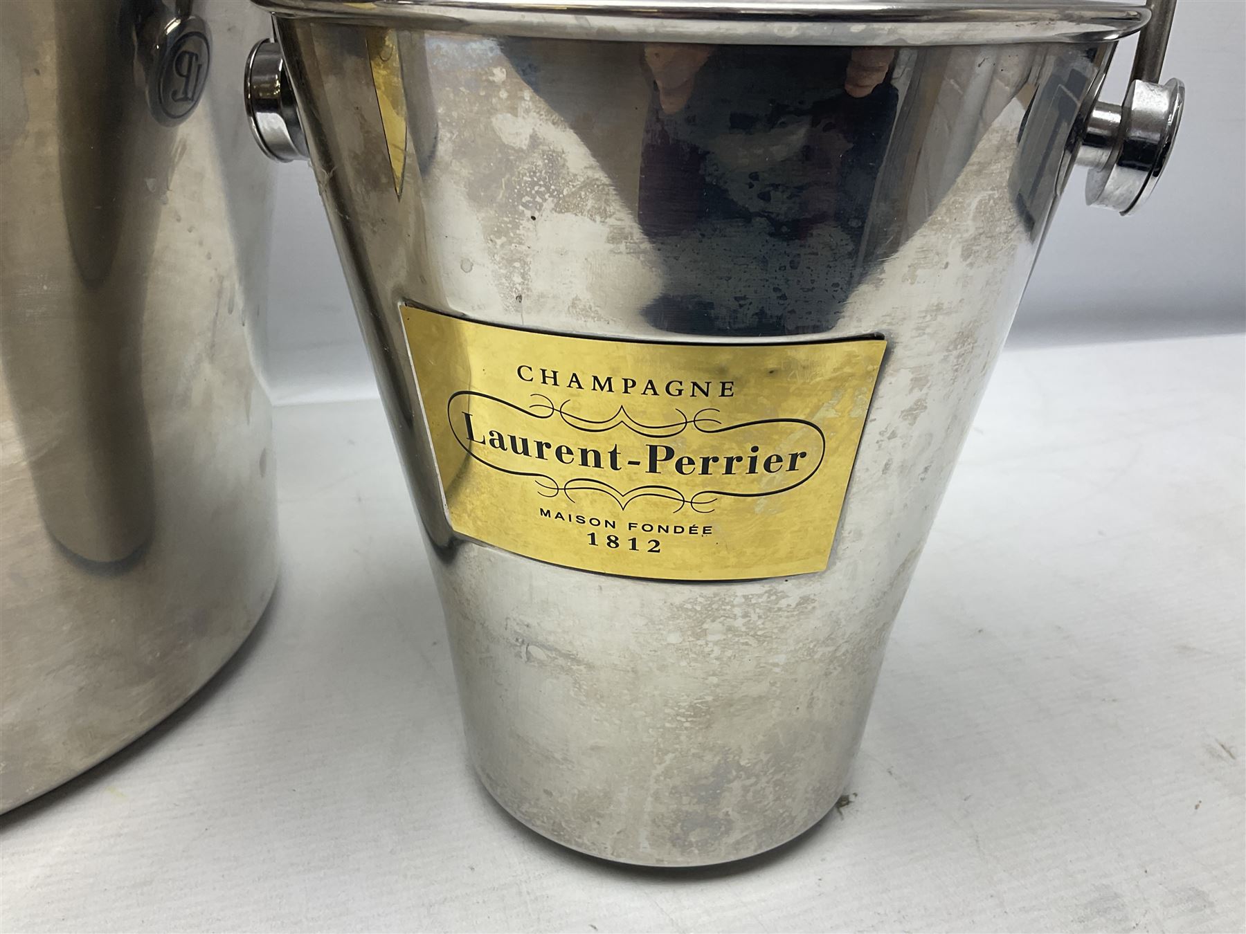 Stainless steel Laurent-Perrier champagne bucket, with engraved brass plaque and grip to swing handle, together with two matching smaller, largest D38cm (3)