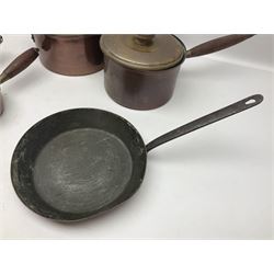 Four Victorian copper moulds, together with a graduating set of copper pans with wooden handles and finials to covers, largest pan 