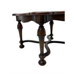 Figured mahogany coffee table, shaped moulded top with oval book-matched veneered panels, on turned supports united by waved X-shaped stretchers 