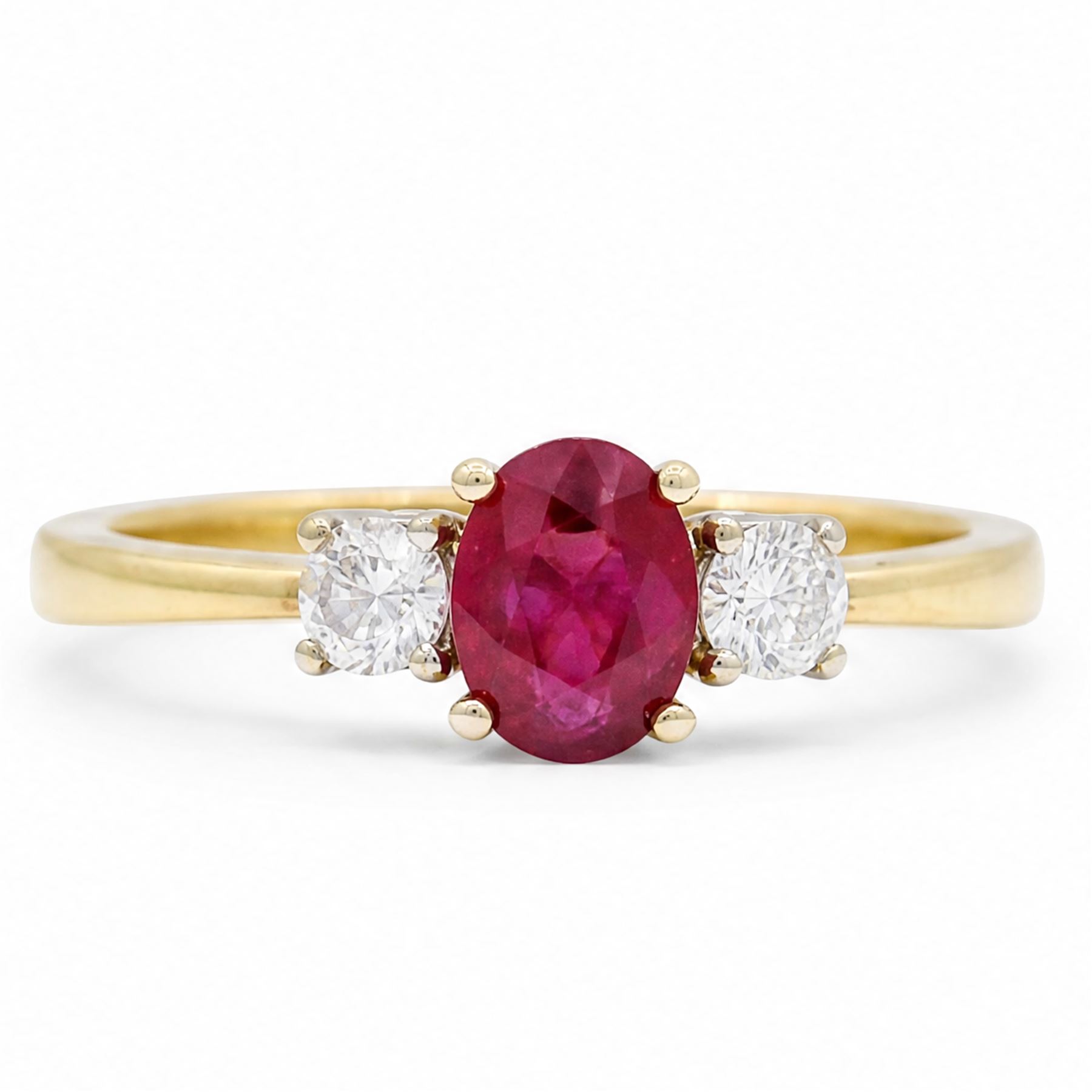 18ct gold ruby and diamond three stone ring, single oval cut ruby of 1.06 carat, with a round brilliant cut diamond set either side, hallmarked, total diamond weight 0.31 carat