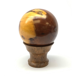 A yew wood sphere, together with a burr cedar stand, overall H22cm.