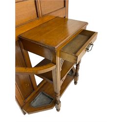 Edwardian oak hall stand, pediment carved with shell and gadroon decoration over reeded and dentil design, rectangular bevelled mirror back surrounded by brass coat hooks, fitted with single drawer flanked by umbrella stands and drip trays