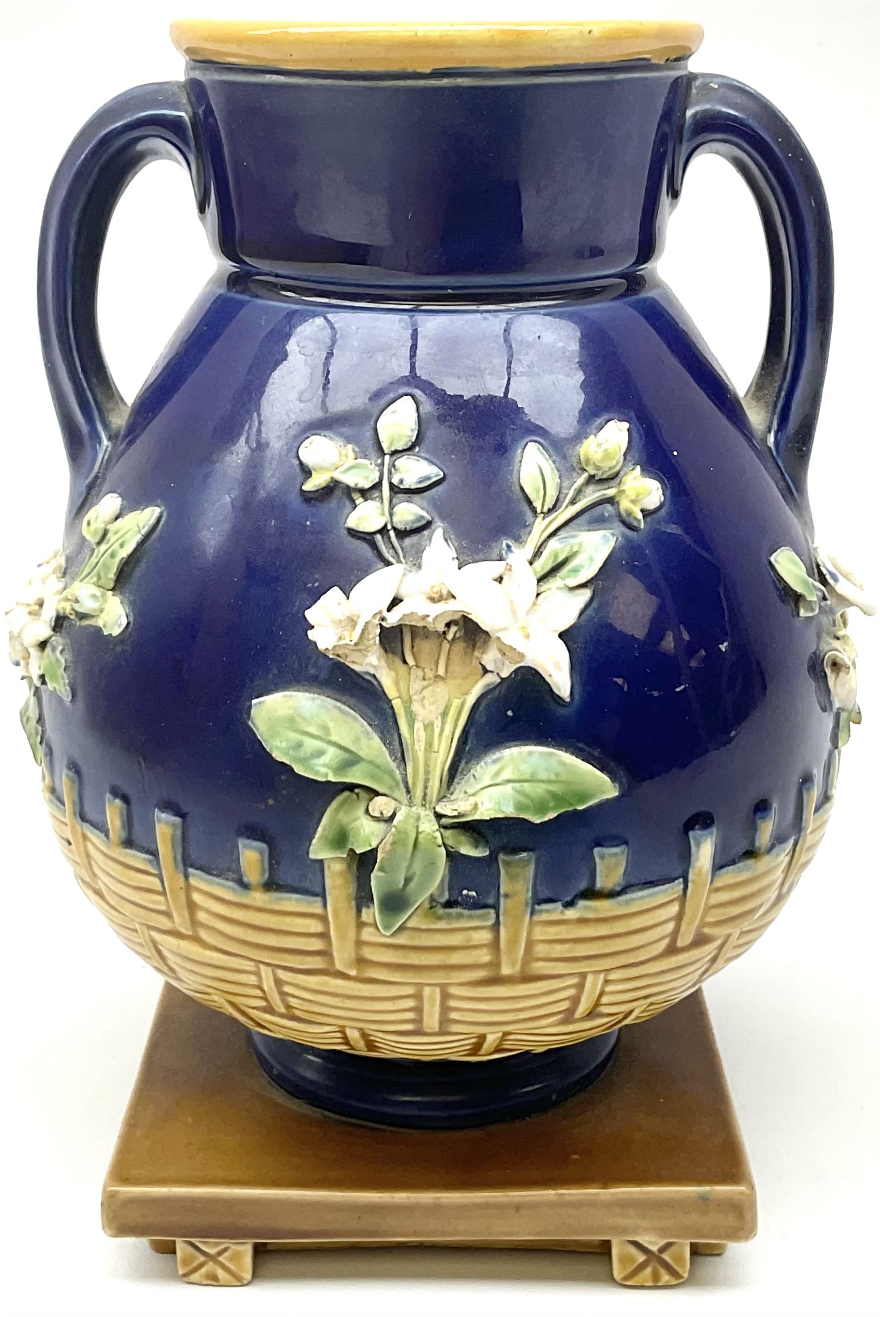 Minton majolica vase, the squat body with twin handles, with part osier moulding and applied Spring flowers against a cobalt blue ground, upon integral square base, impressed beneath Minton 1316, H16.5cm