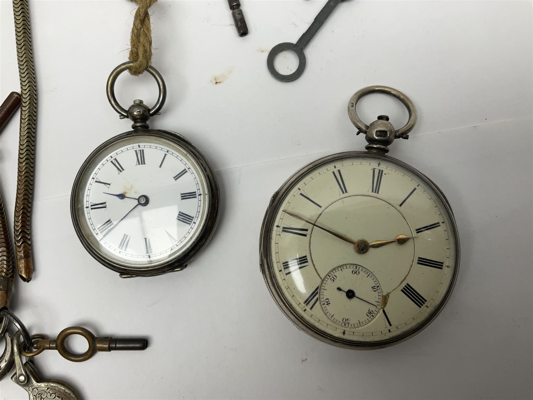 Three Victorian silver lever open face pocket watches including, cream dials with Roman numerals and subsidiary seconds dial, silver cylinder pocket watch and an 8 Jours Hebdomas pocket watch, two silver watch chains and one other chain