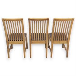 Contemporary oak extending dining table, moulded rectangular top with visible grain and inset extension leaf, pull out extending mechanism, standing on four square legs, accompanied by a set of high slat back chairs with upholstered brown faux leather seats and square tapering supports joined by stretchers