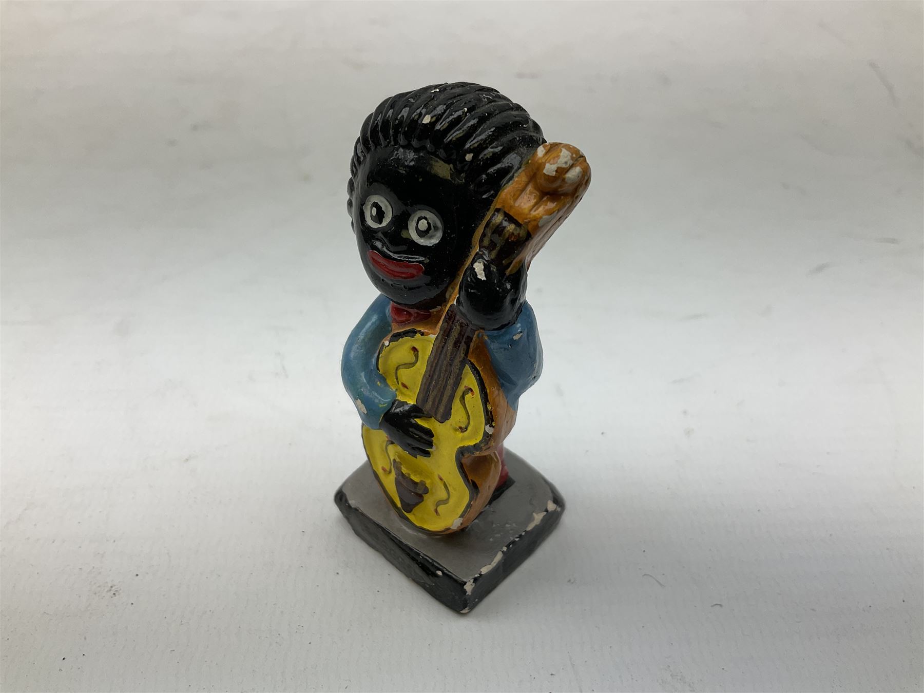 Robinson Jam plaster Golly band, including drummer and singer, H7.5cm

Originally handmade by mothers in Africa for their children from old fabric and cloth, the golly doll was adopted as the mascot and trademark for the Robertson's confectionery brand around 1910 after the company's founder John Robertson visited the US and noticed children playing with them. Robertson's Gollies have been collected by people across the UK and around the world for generations but garnered a contentious image in the 1980s because of links to racism. The trademark was removed from Robertson's branding in 2001.
