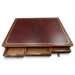 Regency inlaid mahogany and brass mounted library table, the rectangular top inset with gilt tooled burgundy leather writing surface, enclosed by  crossbanding and boxwood stringing with roundel corner motifs, above three cock-beaded frieze drawers to either side fitted with brass ring handles and brass escutcheons, the end friezes centred by applied brass foliate mounts, raised on twin reeded column supports over rectangular platform ends, united by a ring-turned stretcher, the reeded sabre legs terminating in brass caps and castors, one drawer bearing ivorine label 'Spillman & Co., St Martins Lane, London'