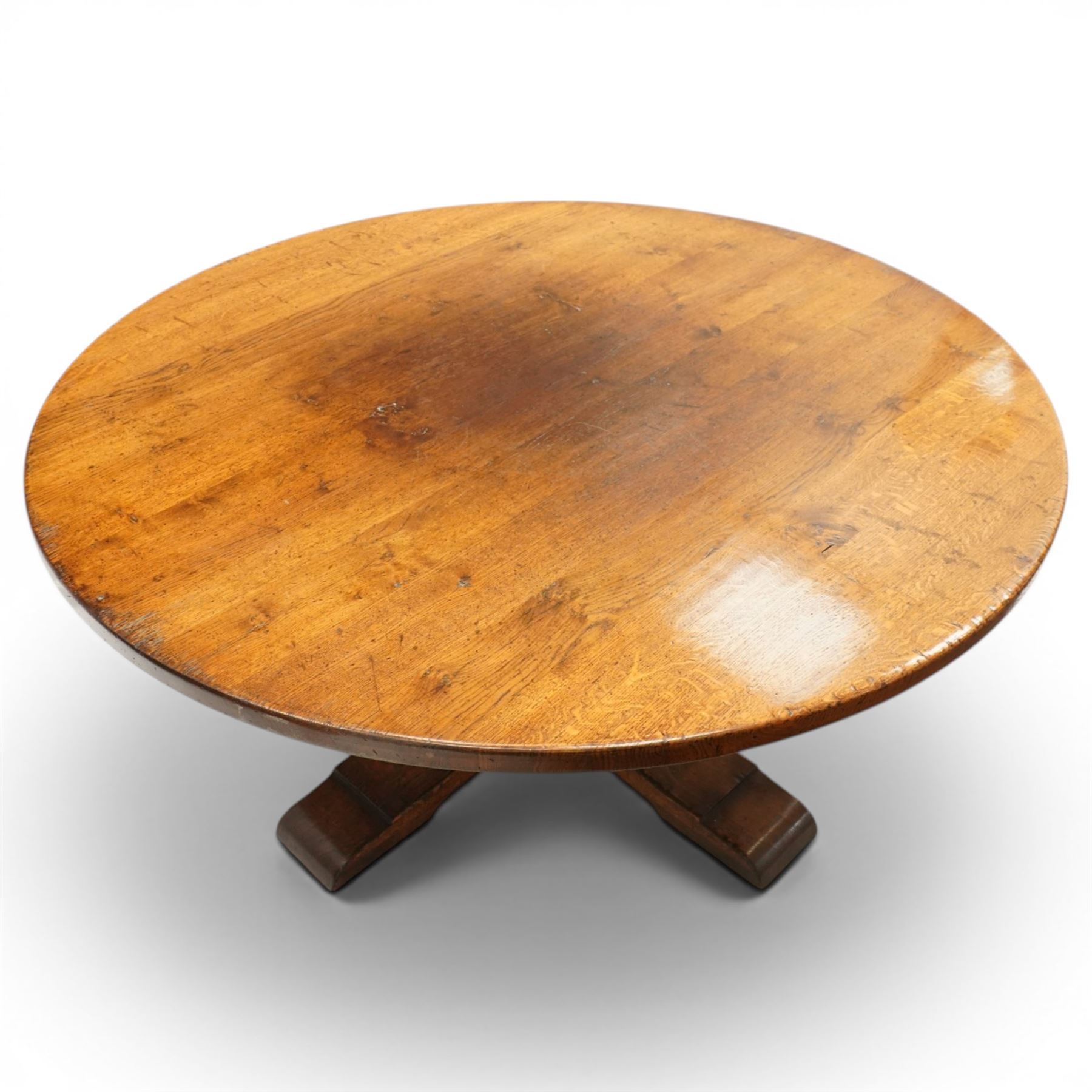 Early 20th century oak centre table, the large circular top raised on a squared and turned baluster pedestal, terminating to four splayed supports