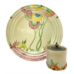 Clarice Cliff plate decorated in the Rhodanthe pattern in pink, yellow and green colourway on cream ground, together with a cylindrical preserve jar and cover decorated in the My Garden pattern with orange and yellow flowers on plain ground, both with factory stamps to reverse, jar H10cm, plate D28cnm