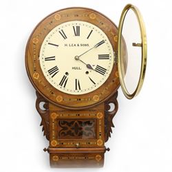 Lea & Son of Hull-American 8-day inlaid mahogany wall clock, with a curved base and carved ears flanking a glazed case door with open fretwork, 12” painted dial with Roman numerals, minute track and spade hands, spring driven movement with a countwheel strike, striking the hours on a bell. With pendulum.
