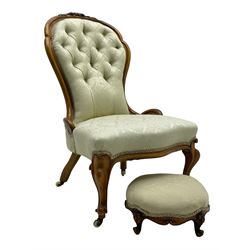 Victorian walnut framed nursing chair, the cresting rail decorated with carved applied flower heads and acanthus leaves, shaped back and sprung seat upholstered in buttoned ivory damask fabric, serpentine front over cartouche carved cabriole supports with ceramic castors (W57cm H92cm); with matched footstool, circular top over shaped moulded apron, on floral carved cabriole feet (W34cm) 