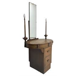 Art deco oak dressing table, raised back with rectangular swing mirror, oval top with flanking electric candlesticks, the frieze with central floral panel and two drawers, over two central drawers