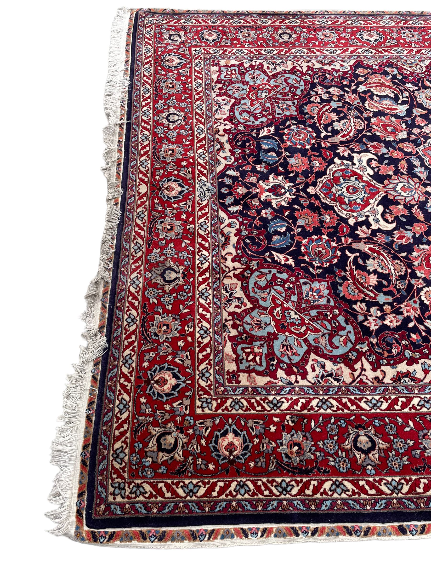 Persian Hamadan indigo ground rug, central floral crimson pole medallion surrounded by trailing foliate decoration and stylised plant motifs, the main guarded border with repeating stylised flower heads, densely knotted