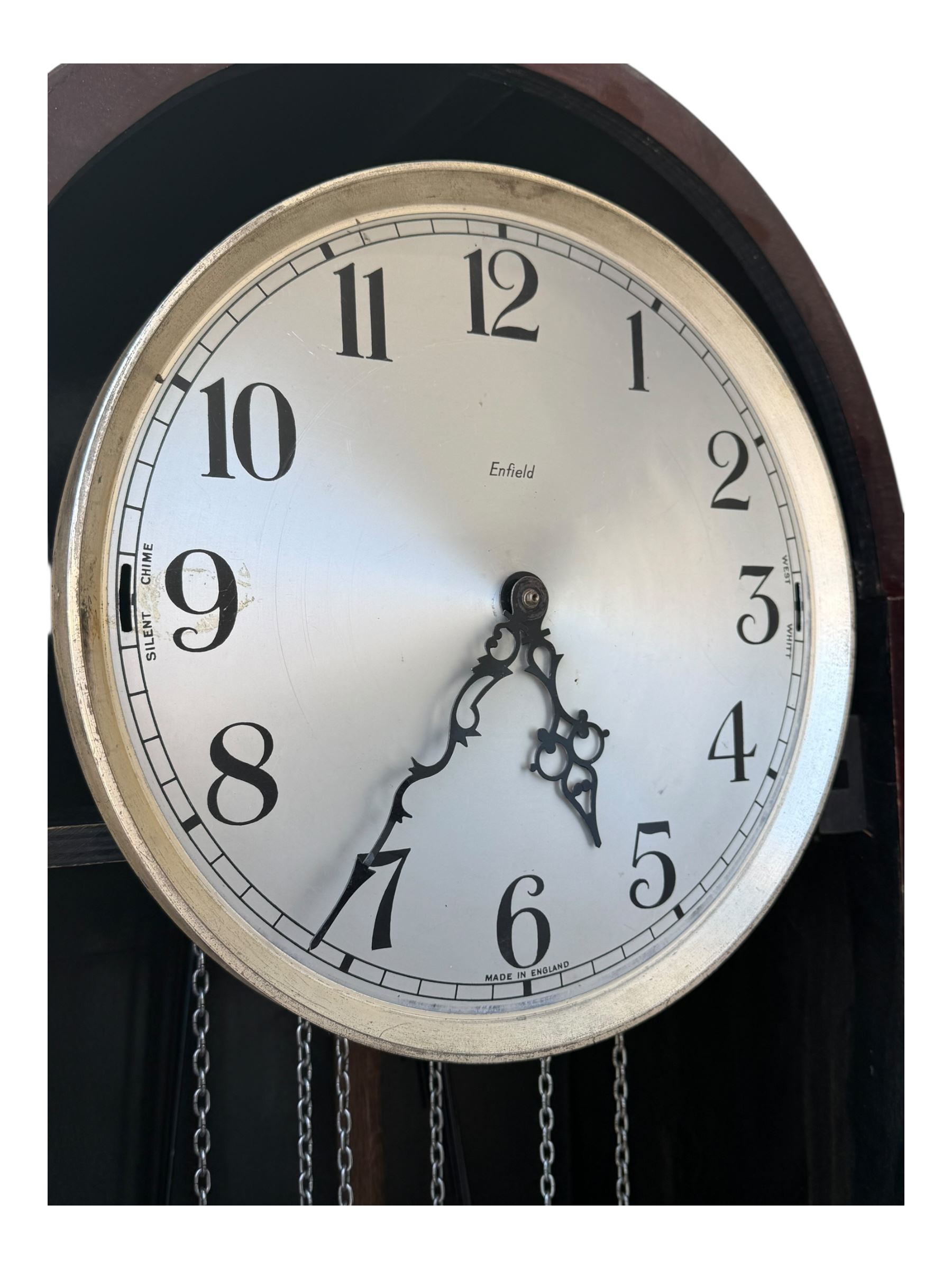 English- Art deco mahogany 8-day longcase clock, with an arched top and fill length fully glazed door beneath, on a short plinth with bracket feet, three train chain driven movement with visible stainless steel cased weights and pendulum, silvered dial with Arabic numerals, minute track and pierced steel hands, quarter chiming movement with  Westminster/ Whittington/ strike/silent selection.

