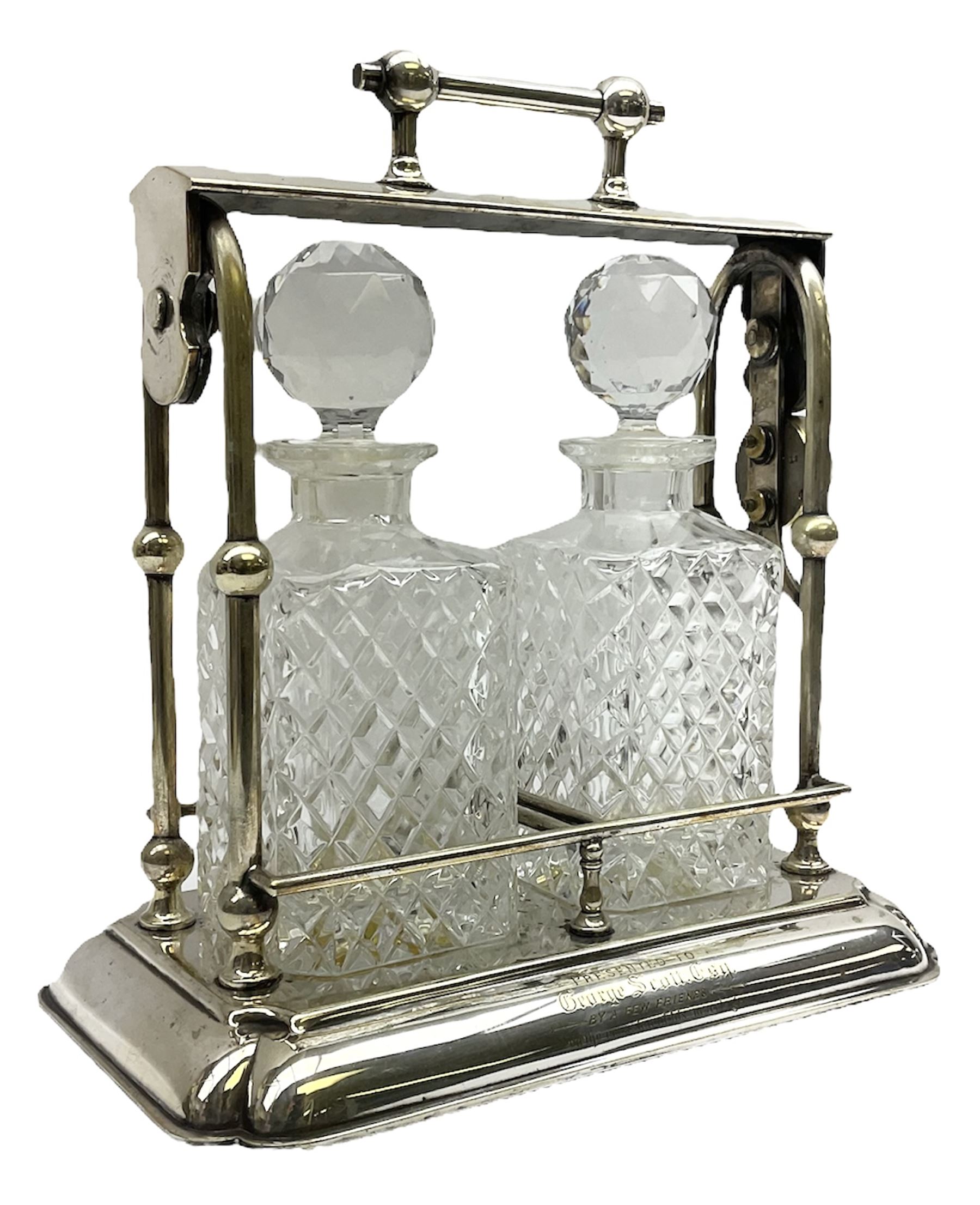 Early 20th century silver plated tantalus by John Grinsell & Sons of Birmingham, containing two crystal glass decanters, with key, H31cm