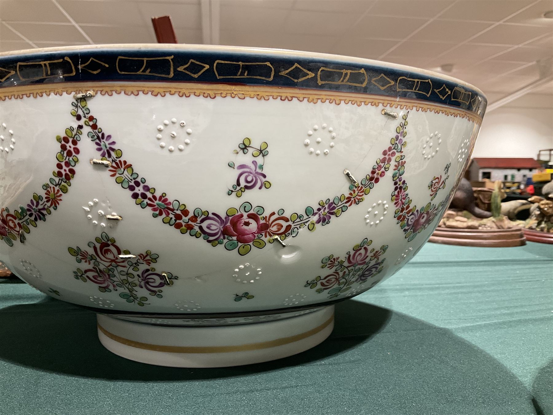 19th century Samson style punch bowl, decorated in the manner of a Chinese export example, with floral sprays and gilt highlighted cobalt blue double border to rim, with armorial crest to exterior, red mark beneath, D35cm