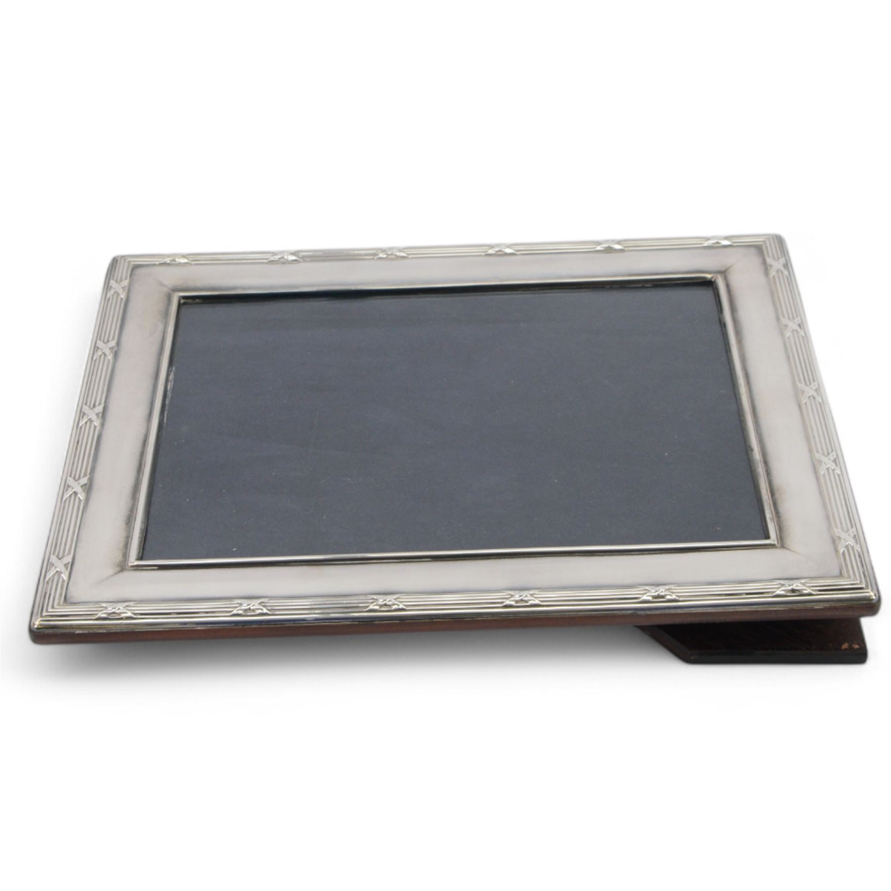 Modern silver mounted photograph frame, of rectangular form with reed and ribbon border, hallmarked Carr's of Sheffield Ltd, Sheffield 2000, together with a silver napkin ring and a silver Port decanter label, both hallmarked, frame H26cm x 21cm