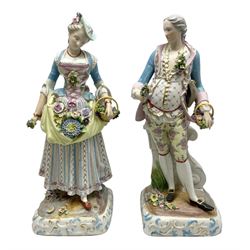 Large pair of late 19th century Continental figures in the Meissen style, modelled as a gardener and companion in 18th century dress, holding baskets of flowers and posies, each upon naturalistically modelled floral encrusted square base with scroll moulded sides, with underglaze blue cross sword type marks beneath, tallest example H49cm