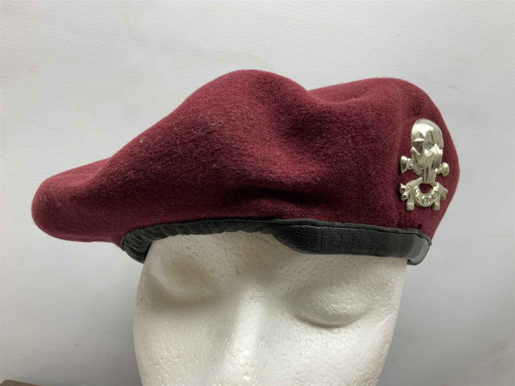 Assorted militaria including ten leather or canvas cartridge and other belts, maroon beret with 17th Lancers cap badge, modern bullet mould, leather and brass shot flask, two knives, shell cases, boomerang etc; in tin deed box