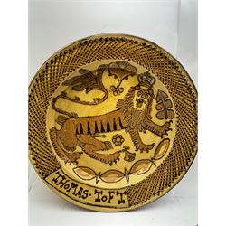 John Hudson: Large slipware charger in the style of Thomas Toft by John Hudson of Mirfield Pottery, decorated with the lion supporter taken by Toft from the Royal Arms, incised marks verso, D 44cm.
