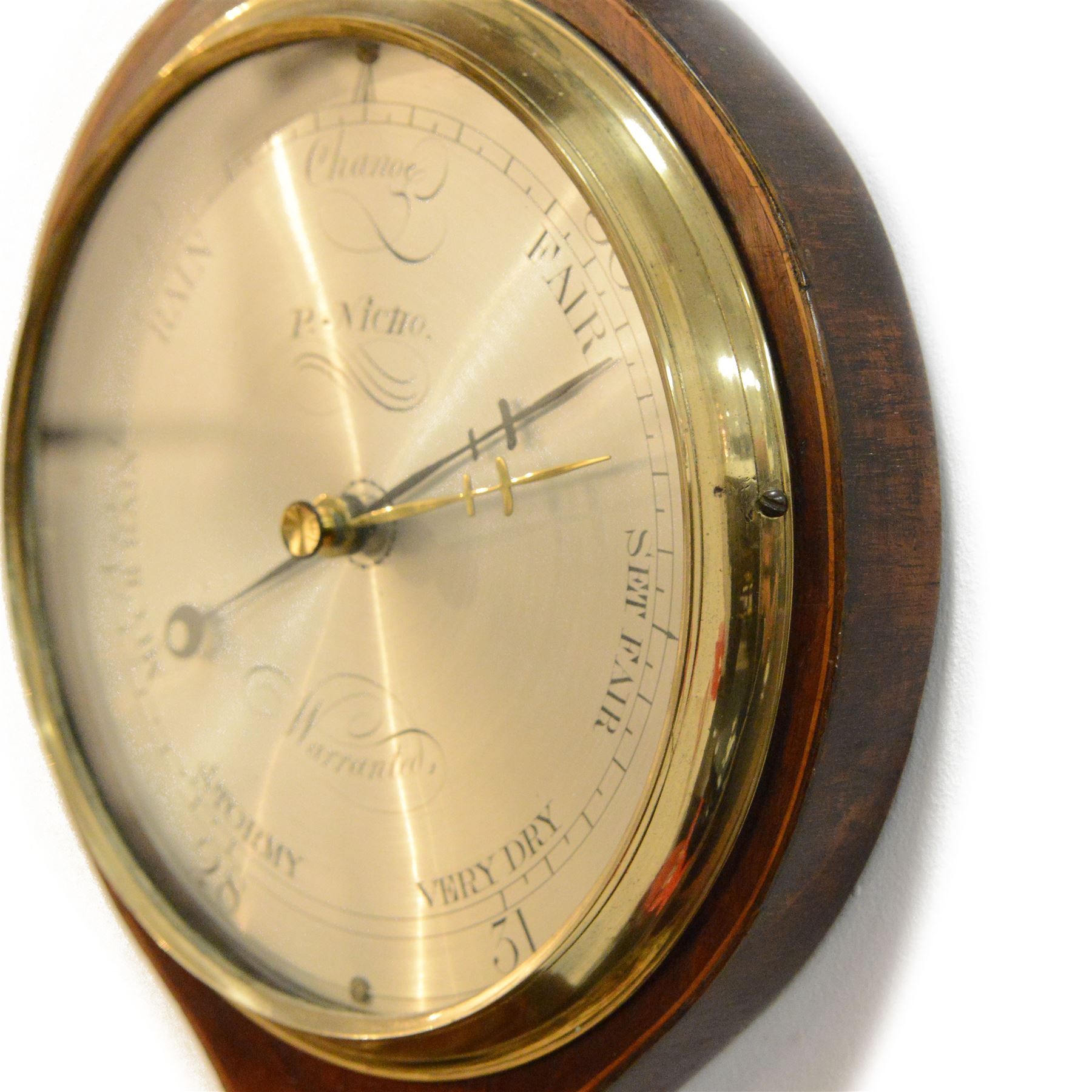 Early 19th century-Sheraton two instrument mercury barometer c1820, with a break arch top and round base, mahogany veneer with inlaid motifs and stringing to the edge, surface mounted mercury thermometer recording degrees Fahrenheit and an 8” silvered register with predictions and recording barometric air pressure from 28 to 31 inches, with a steel indicating hand and brass recording hand. Dial inscribed P. Nicho. 
Mercury present, syphon tube and pulleys intact.