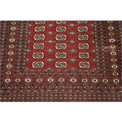 Two hand-knotted rugs, comprising Turkoman Ersari rug and Bokhara rug, Turkoman Ersari hand-knotted rug, terracotta ground with two rows of repeating octagonal guls interspersed with geometric motifs, enclosed by multiple geometric borders, fringed ends, H125cm, W93cm; Bokhara hand-knotted rug, madder red ground with three rows of repeating Tekke guls interspersed with geometric motifs, enclosed by multiple stylised floral and geometric borders, fringed ends, H188cm, W126cm