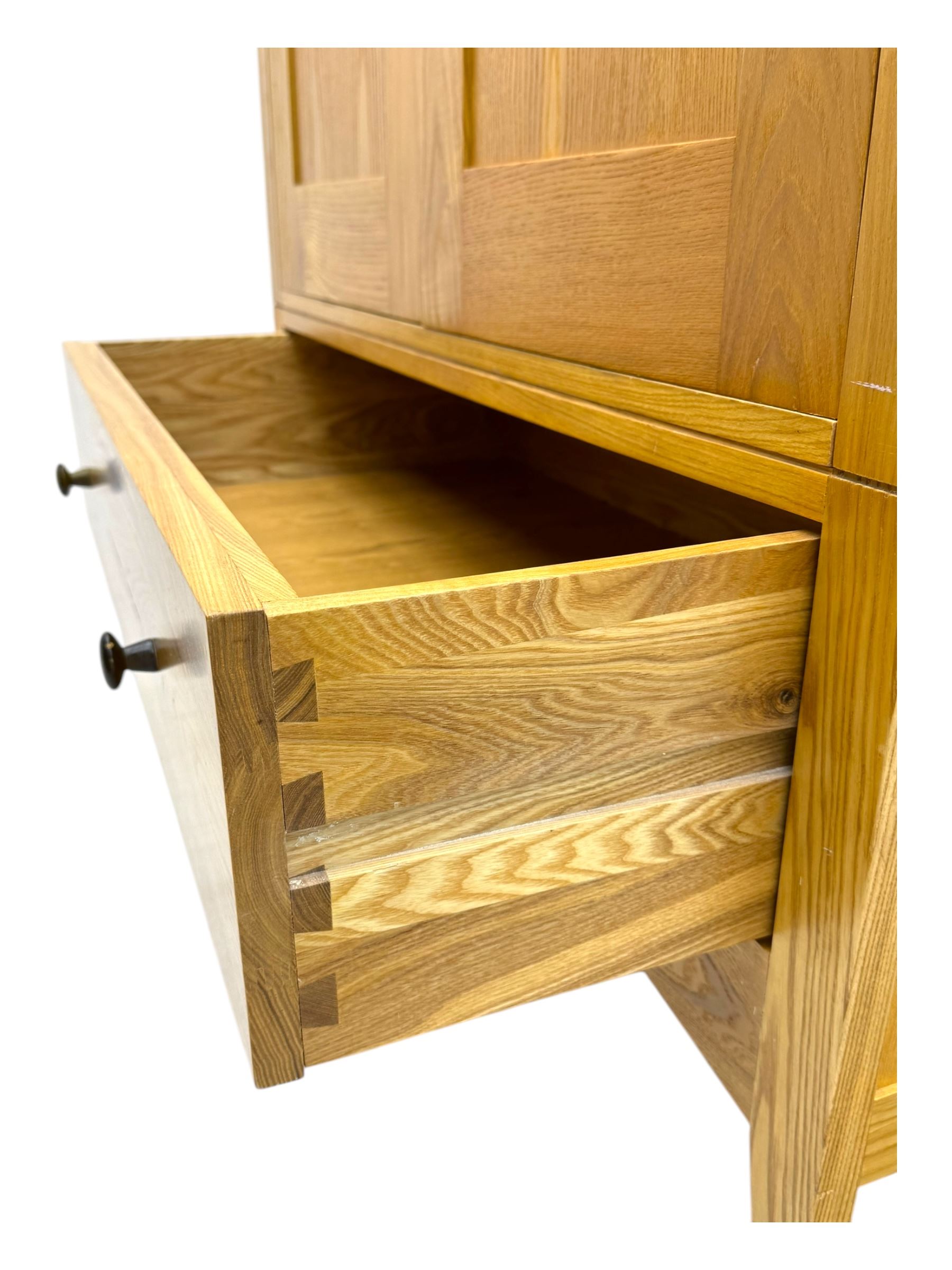 Contemporary light oak double wardrobe, projecting cornice over two panelled doors enclosing hanging rail and shelf, above full-width drawer, on shaped stile supports