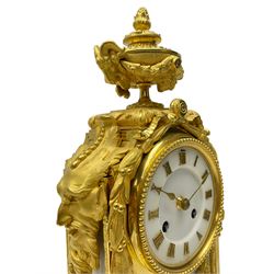 French late 19th century 8-day gilt ormolu mantle clock on a padded base – with urn surmount and floral garland crest on lobed disc cast feet, white marble two-part dial and panel beneath, dial with applied Roman numerals and gilt spade hands, Parisian rack striking movement, striking the hours and half hours on a bell. With pendulum and key.  