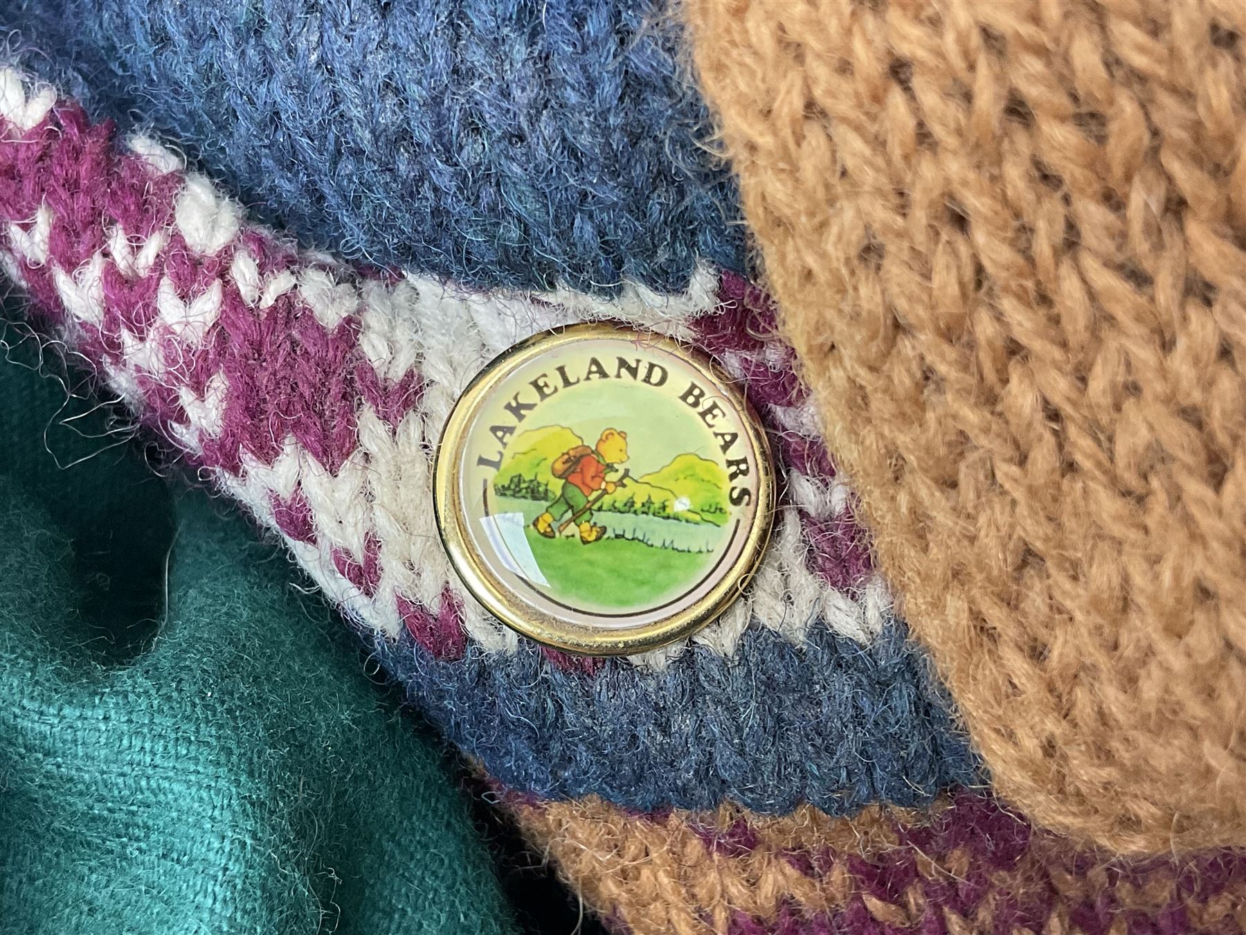 Lakeland Bears teddy bear, titled 'Walkright', dressed as a hiker in green corduroy duffle coat over fair isle jumper, trousers and knit socks, complete with leather clogs with wood soles, walkers thumb stick, knitted scarf, flat cap and rucksack housing original tag and map, H50cm