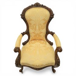 Victorian carved walnut open armchair, shaped and moulded frame with foliate carved cresting rail, upholstered back and seat in yellow damask fabric, scroll arms with padded rests, carved cabriole supports terminating in ceramic castors