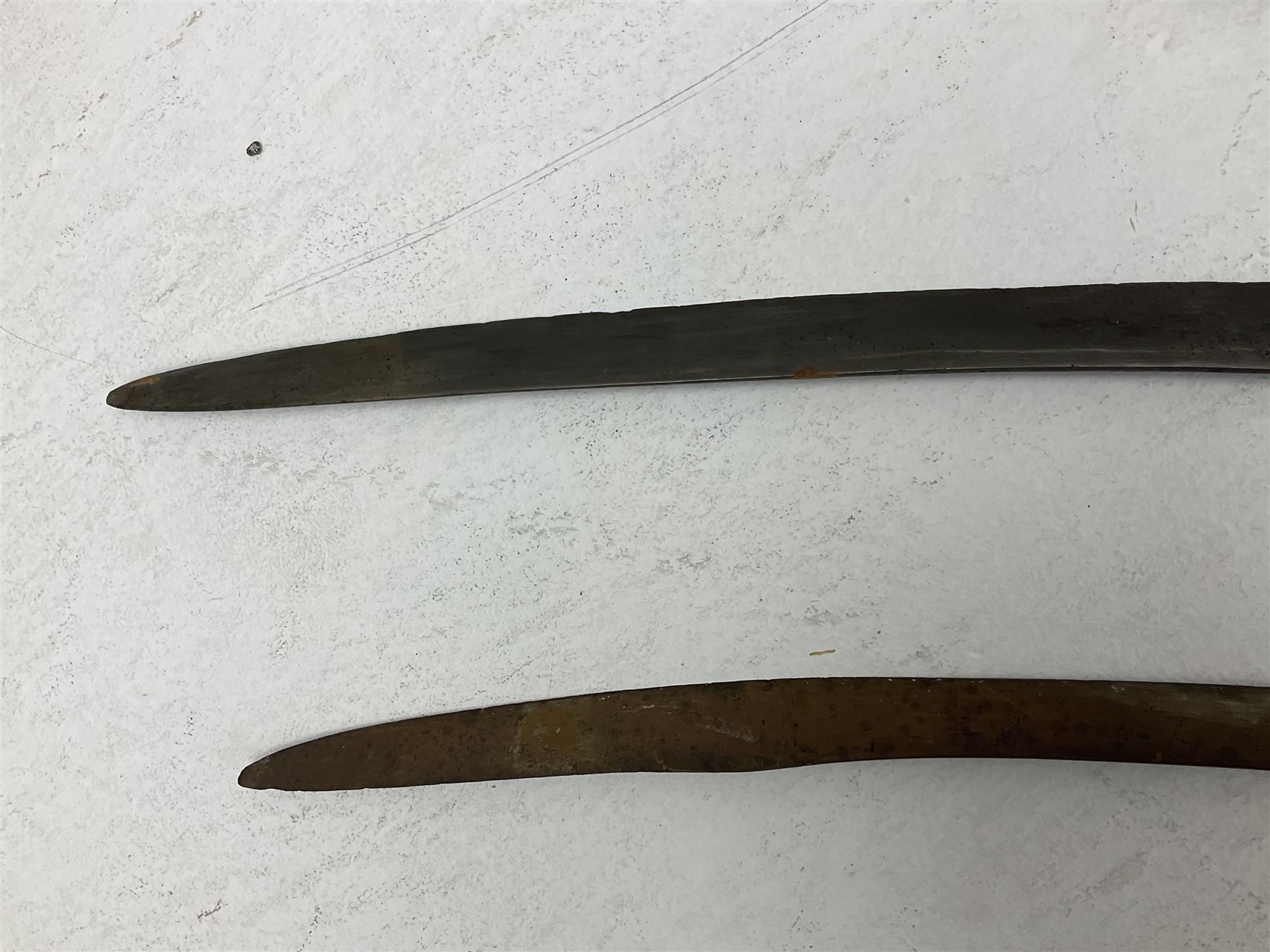 Late 19th/early 20th century Indian Tulwar sword with 81cm plain curving steel blade and iron hilt with extended langets, knucklebow and spiked pommel; in leather covered scabbard L100cm overall; and another Tulwar lacking scabbard in almost relic condition (2)
