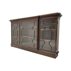 Early 20th century mahogany breakfront wall hanging bookcase, projecting dentil cornice over astragal glazed doors