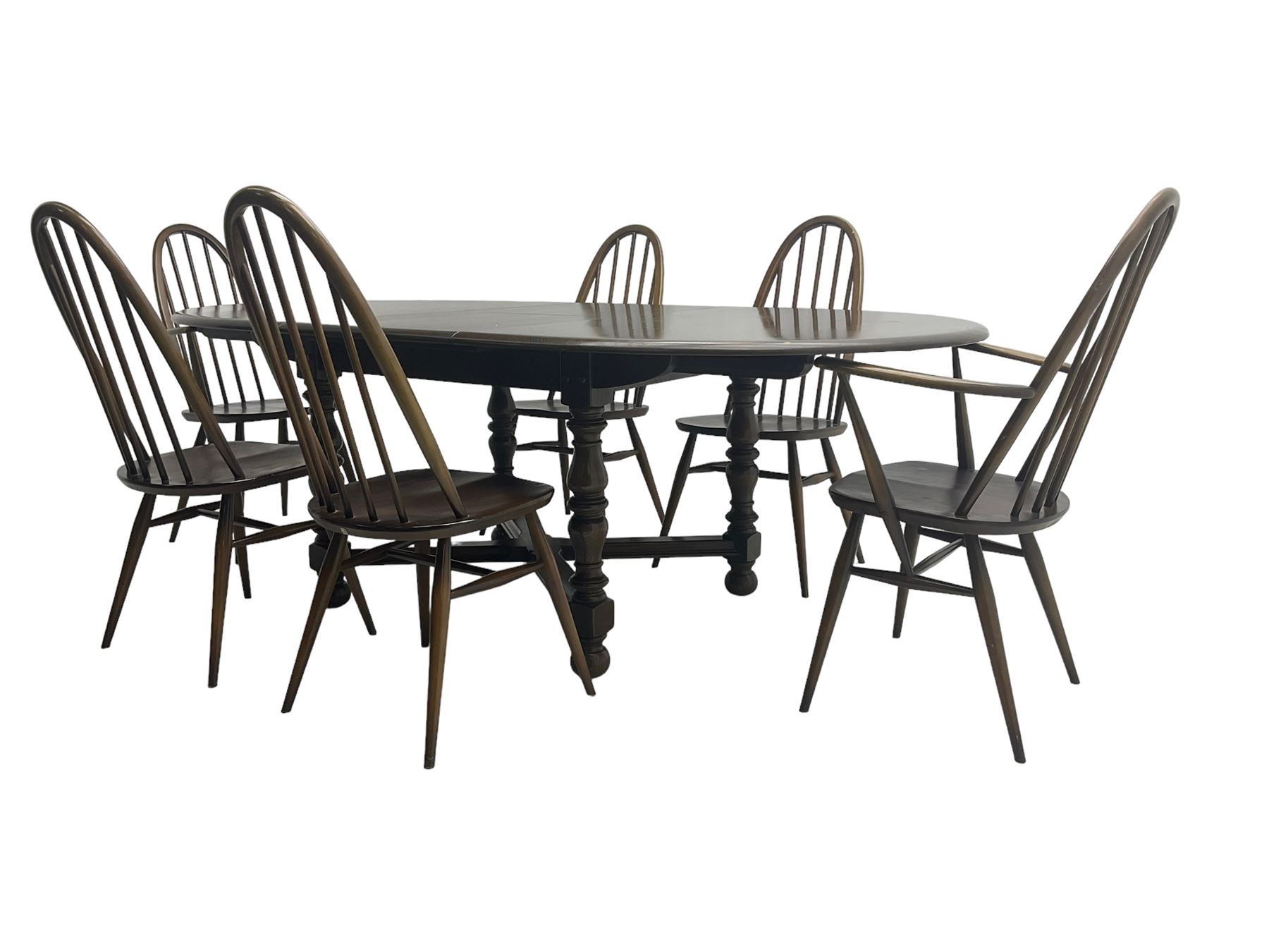 Ercol - 'Old Colonial' 705 elm extending dining table, oval top with hidden leaf, raised on turned supports united by X-stretcher (W163cm D108cm H72cm); and Ercol - set six  (4+2) dark elm 'Quaker Back Windsor Dining Chairs', hoop and stick backs 