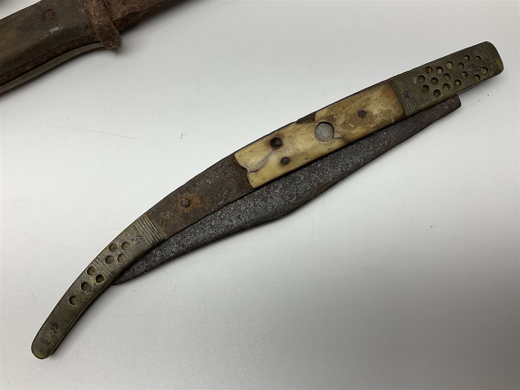 19th century continental folding knife with 15.5cm single edged blade, the pierced brass and iron handle with remains of horn grips L21.5cm overall closed; turned horn handled knife with foliate engraved blade; battlefield relic German 1884/98 knife bayonet; iron spear head; leather covered swagger stick; and two-piece gun cleaning rod
