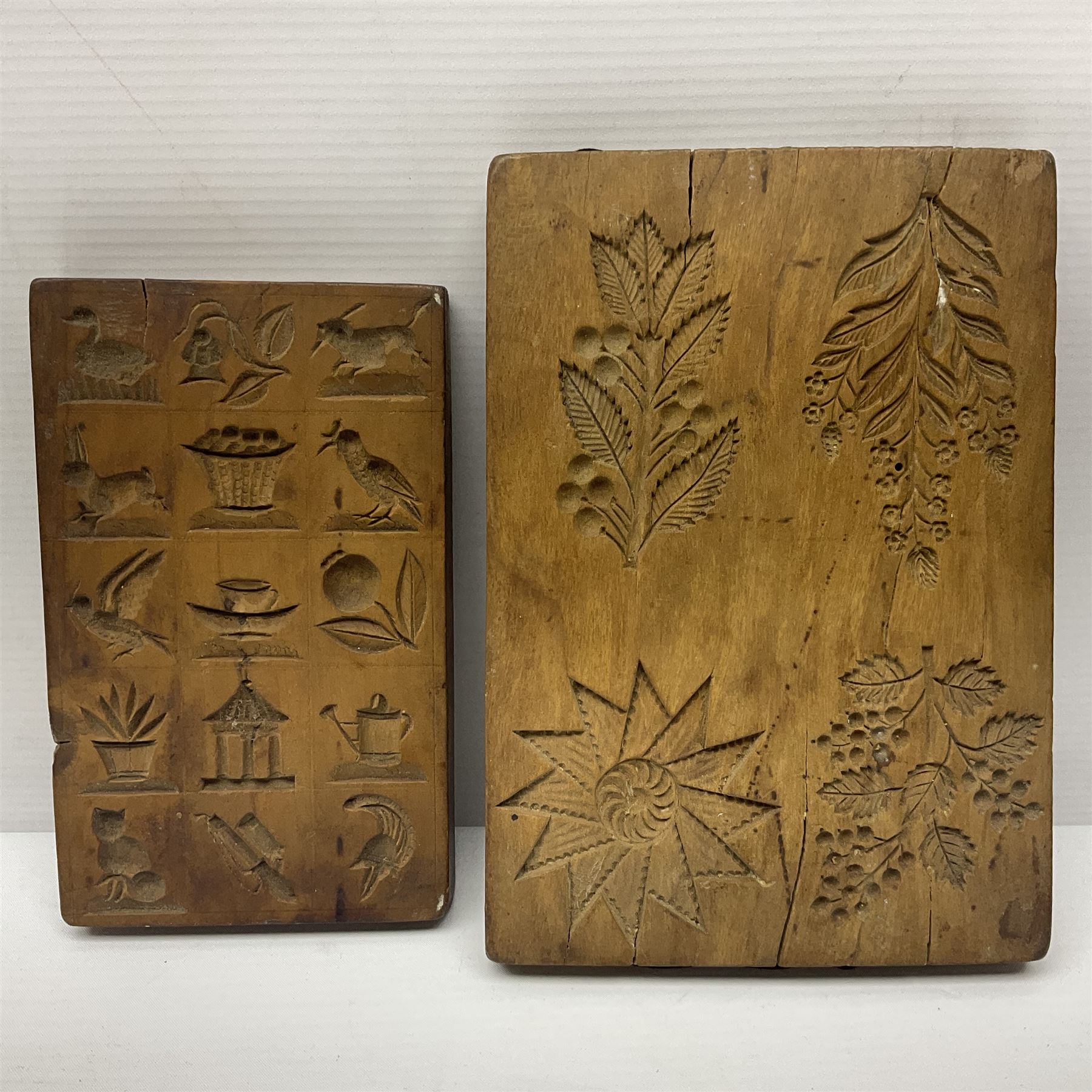 Two wooden biscuit moulds, carved loving spoon and fork, and two bradawls 