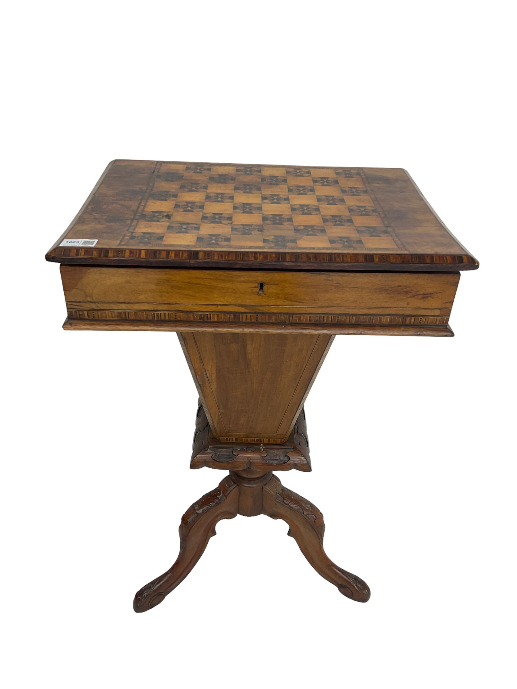 Victorian walnut work table, the rectangular hinged top inlaid with a chessboard design, canted edge with alternating ebony and satinwood inlays, concealing fitted interior, banded and strung frieze over tapering column well, collar carved with foliate decoration, on a cabriole tripod base