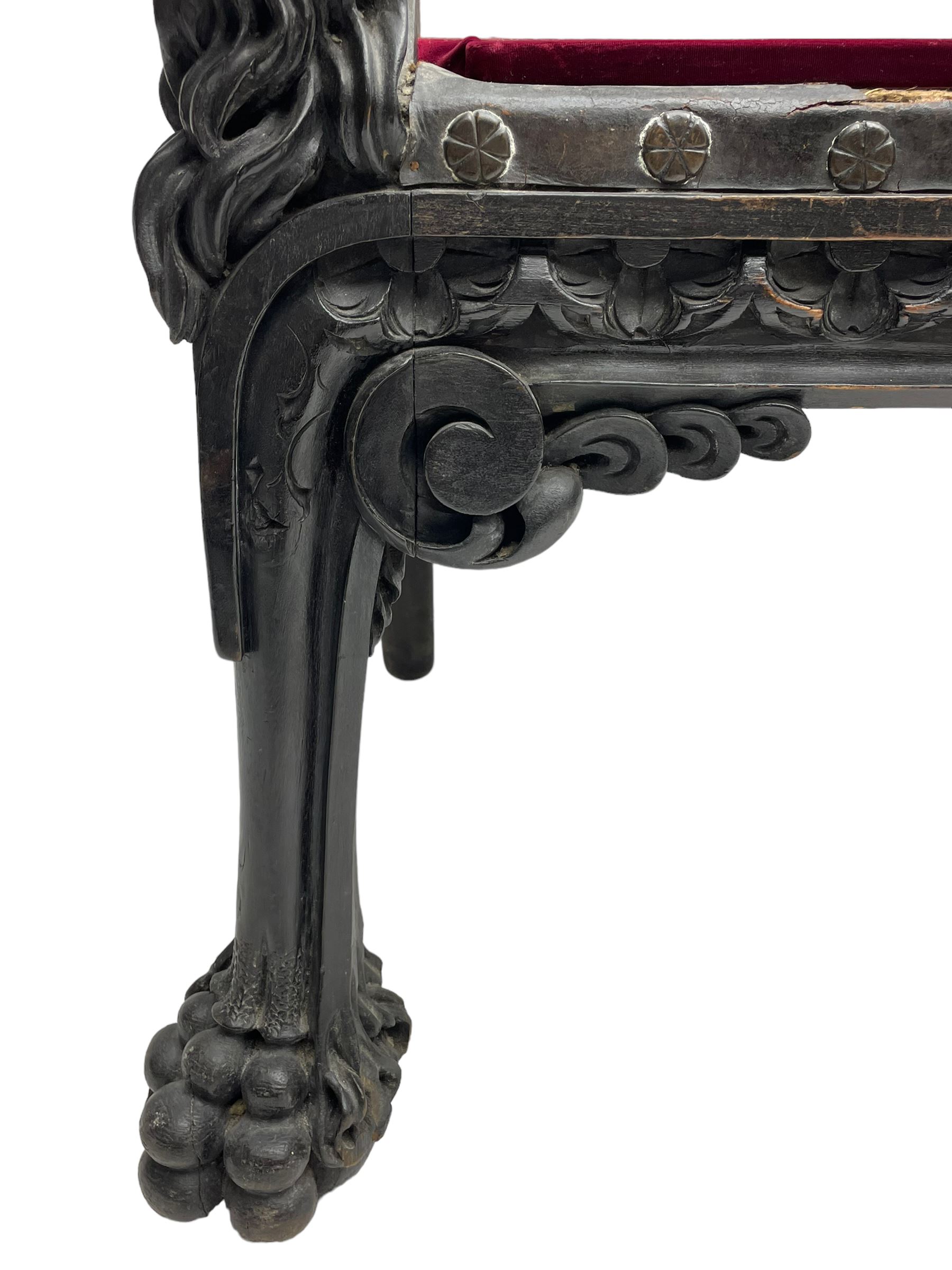 Grand mid-to-late 19th century heavily carved beech framed throne chair, the crown pediment carved with flower heads and cross finial, scroll and acanthus carved upright supports with twin perching griffin back enclosing etched leather work heraldic shield with castle and lion motifs over splayed feathers, flower head carved down sweeping arms with grotesque carved terminals, the seat rails carved with further flower heads on moulded supports with oversized ball and claw carved feet

Provenance: A very similar chair was used in the filming of Stanley Kubrick's 'Eyes Wide Shut' (1999)
