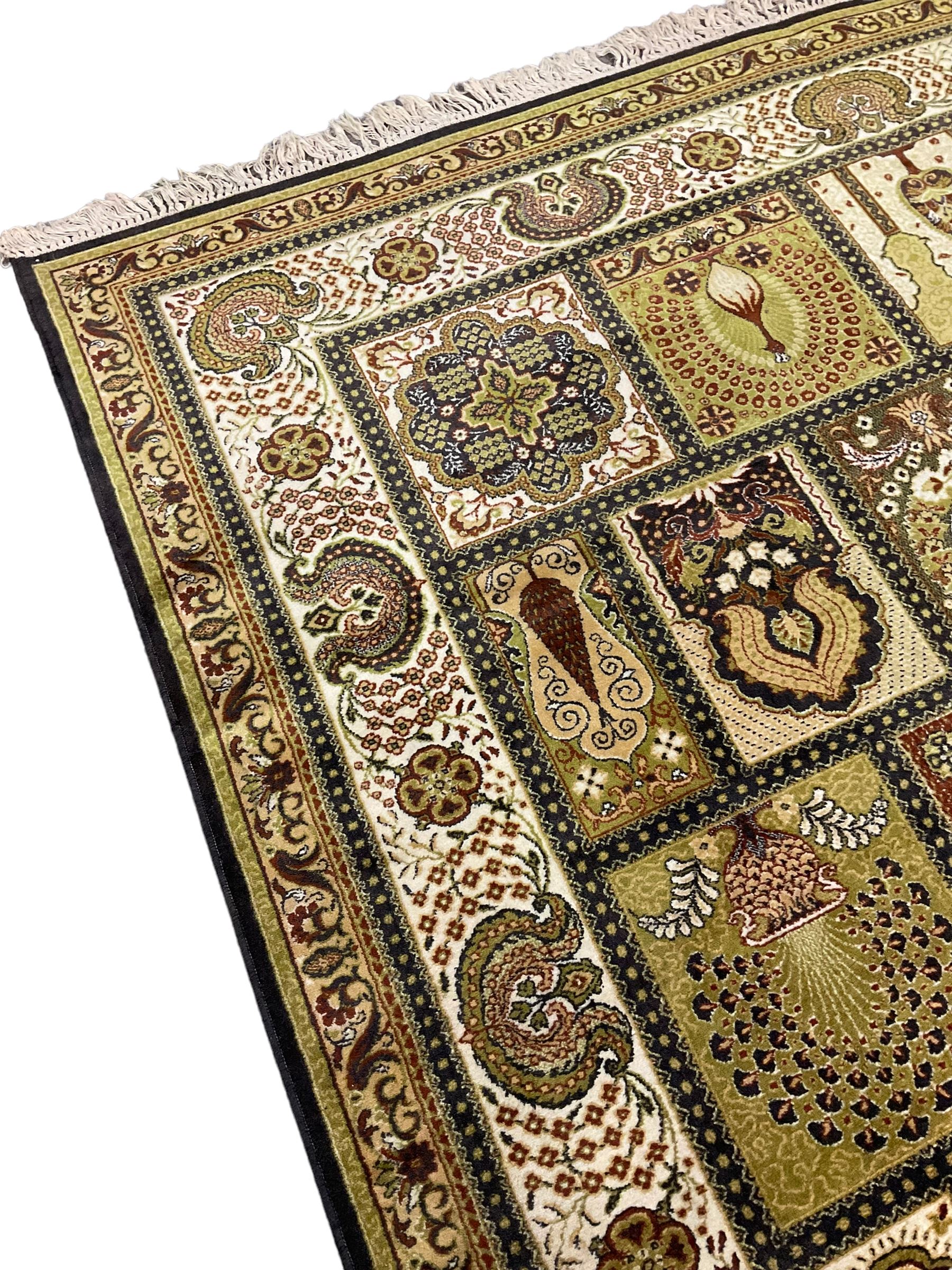 Persian design carpet, the field with various size tiles decorated with stylised plant motifs, floral urns and peacocks, the main border decorated with repeating foliate motifs and trailing flower heads