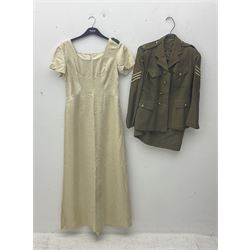 WW2 British female ATS Sergeant's service uniform grouping, consisting of four pocket female pattern service dress tunic with brass ATS shoulder titles and general service buttons; cloth lined interior with the original printed size label dated 1942; the matching khaki service dress skirt; and Greatcoat with size label dated 1945; together with army knitted sleeveless V-neck jumper; WRAC tunic, skirt and overcoat; full length cream and gold thread military evening dress by Hilliers Couture; and four webbing belts