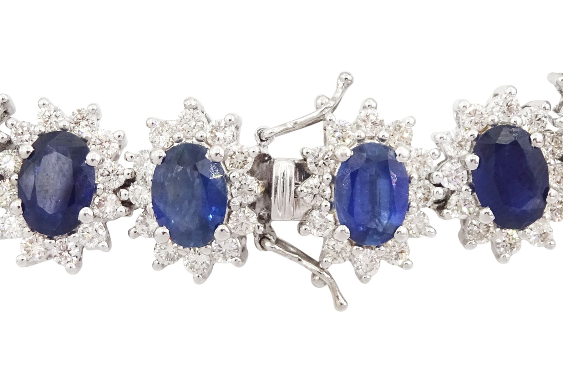 18ct white gold sapphire and diamond bracelet, nineteen clusters each set with a single oval cut sapphire and round brilliant cut diamond surround, stamped 750, total sapphire weight 18.20 carat, total diamond weight 6.38 carat