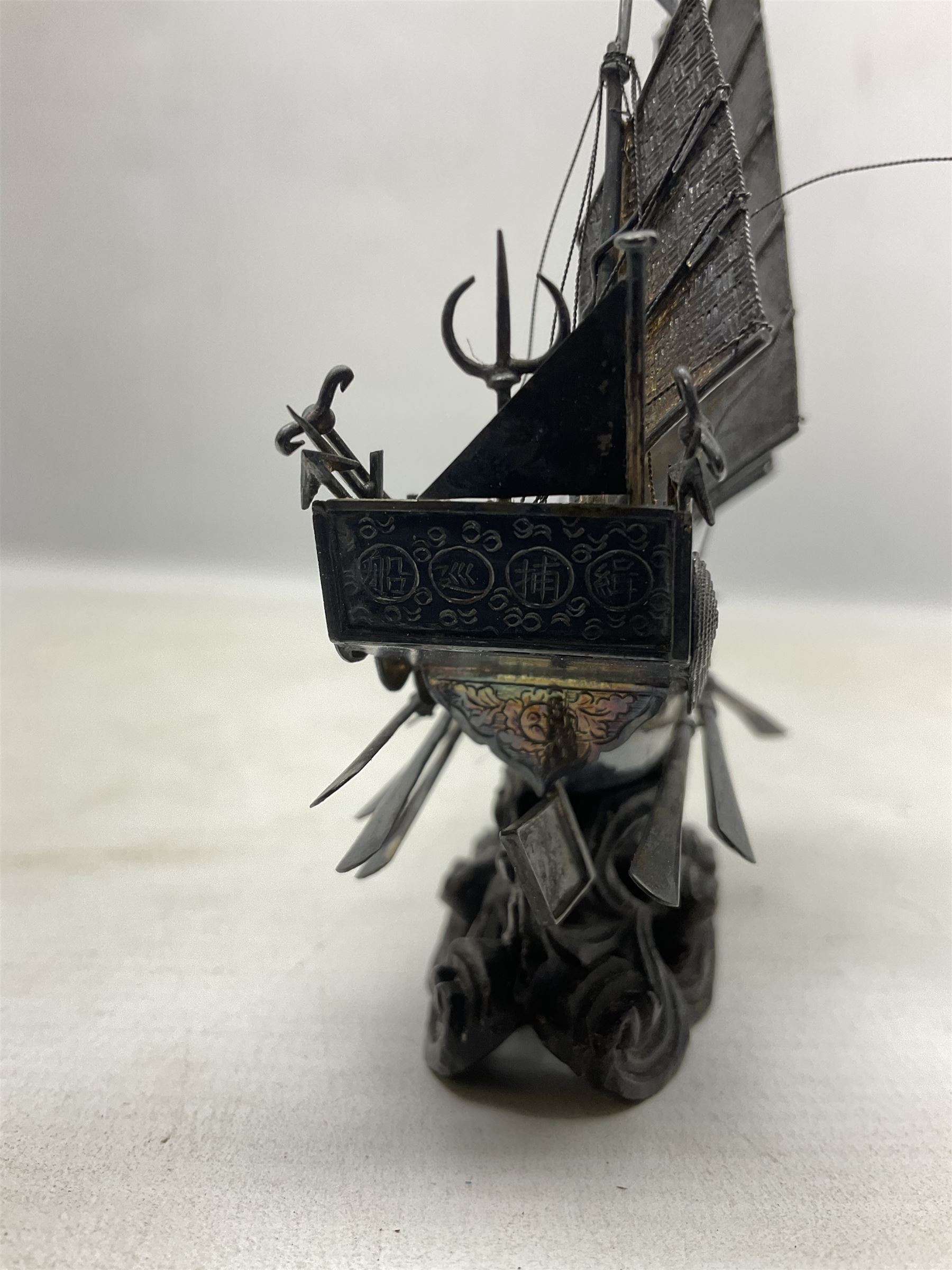 Chinese miniature silver model of a junk ship, with textured sails, mounted upon a carved wooden stand, H14cm