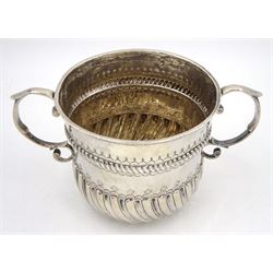 William & Mary silver porringer, the part fluted body with twin scroll handles, and chased and embossed gadrooned borders, inscribed beneath 'Rev. W. H Bps, Hull Michmas 1805', hallmarked London 1697, makers mark LO, H9cm, approximate weight 6.26 ozt (194.9 grams)

