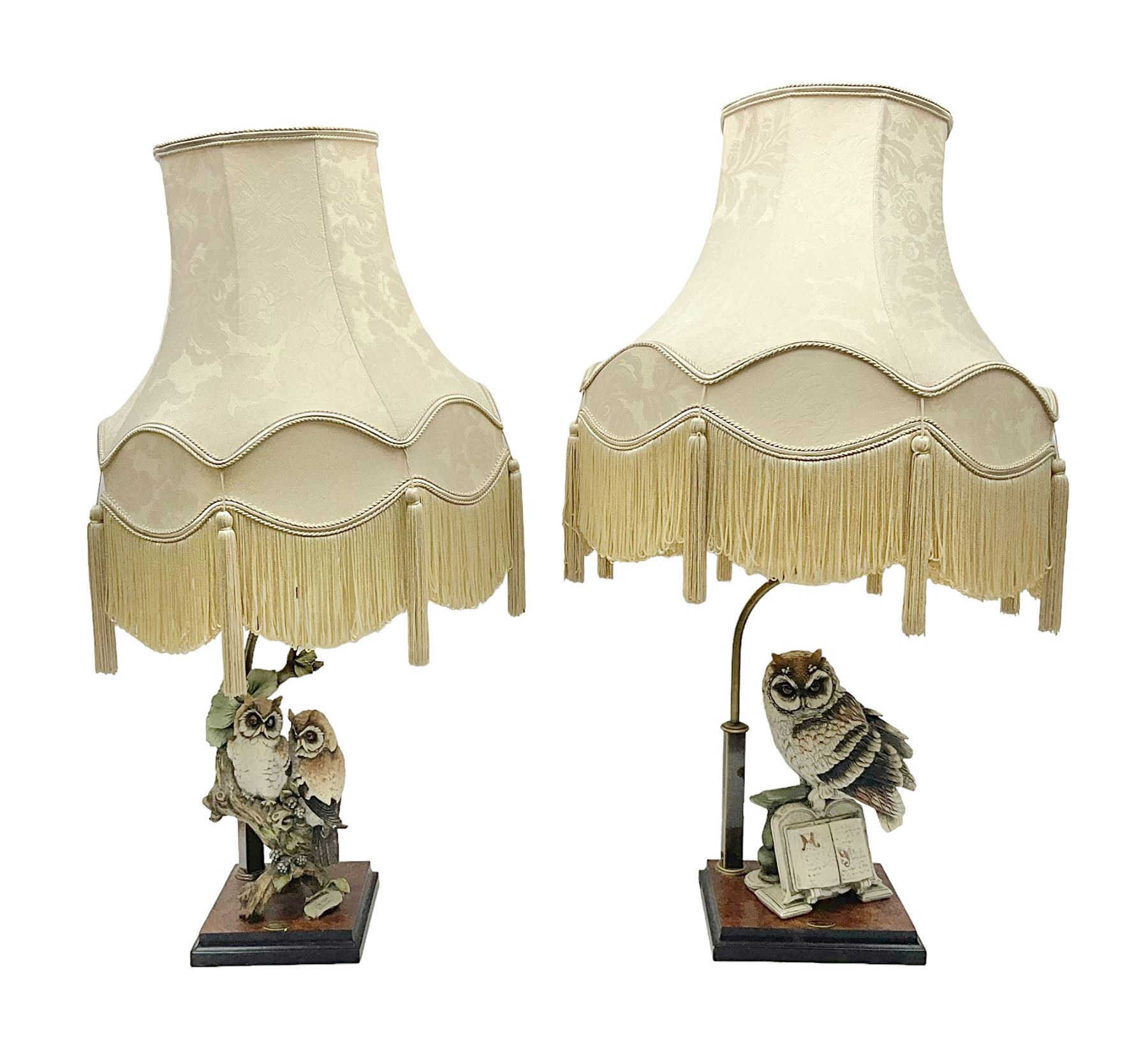 Two Giuseppe Armani figural lamps, the first modelled as an owl perched upon a book, the second modelled as a pair of owls perched upon blackberry branch, each with damask fabric tassel shades, tallest H76cm