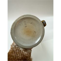 Arts and Crafts or Jugendstil tankard by Richard Riemerschmid, circa 1906, the cylindrical stoneware body reading 'Gaudeamus Igitur' (therefore let us rejoice), and finished in a brown glaze, with engraved slightly domed hinged lid, impressed mark beneath for Reinhold Merkelbach Grenzhausen, model number 2026 W, H14.5cm 